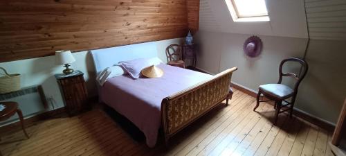 une chambre avec un grand lit et une chaise dans l'établissement agréables chambres d'hôtes près du centre ville avec jardin, au Mans