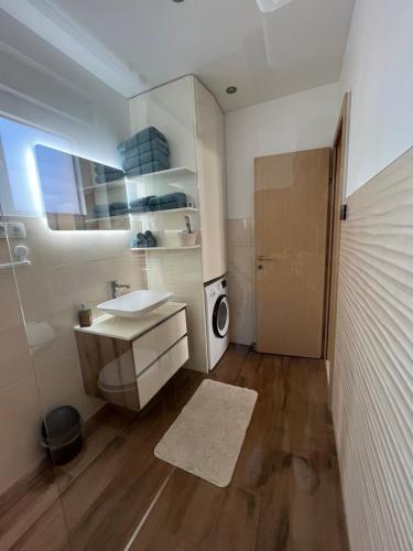 a bathroom with a sink and a washing machine at Poolhouse Flip Flop - mit privatem Pool in Vir