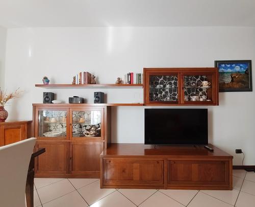 a living room with a television and wooden cabinets at Lully&Jeky -Casa vacanze- in Recanati