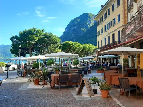 a street with tables and chairs and umbrellas at AnMa Cottages The Secret Garden in Pianello Del Lario