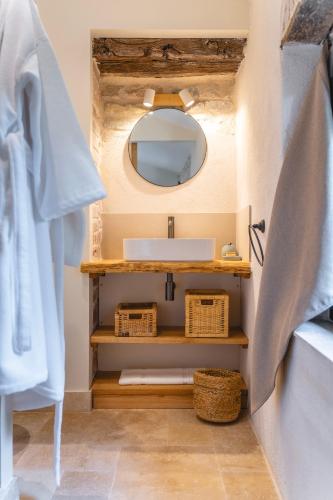 une salle de bain avec un lavabo et un miroir dans l'établissement Gîtes au pied des Cévennes - Domaine Les Terres Aoyama, à Saint Julien Les Rosiers