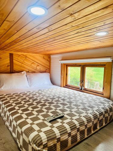 a bed in a room with a wooden ceiling at Riverside La Masía Ecohotel in Quindío