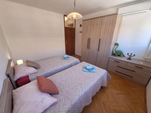 - une chambre avec 2 lits et une commode dans l'établissement Apartment Mangus, à Split
