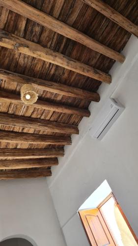 um tecto com vigas de madeira num quarto em Maison d'hôtes "Dar Khalifa" em Tozeur