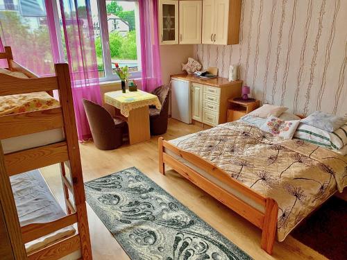 a small bedroom with a bed and a desk and a table at Pokoje Gościnne Razem 10 min do plaży in Władysławowo