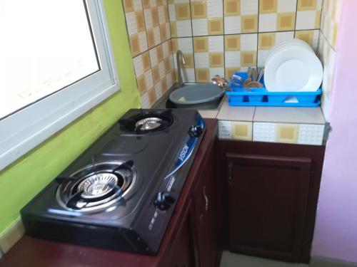 a small kitchen with a stove and a sink at Studio meublé Yaoundé Centre ville in Yaoundé