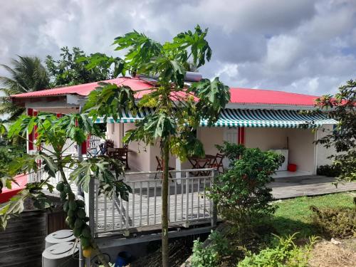 a house with a balcony and a palm tree at Sunset in Sainte-Anne