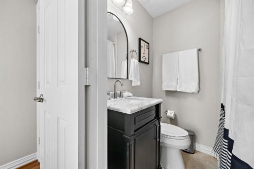 a bathroom with a sink and a toilet and a mirror at The Carriage House Retreat in Houston