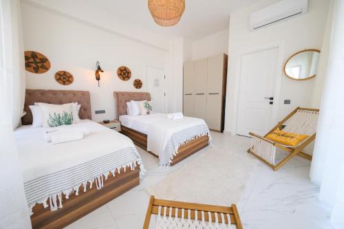 two beds in a room with white walls at Lily of the Valley Luxury Villa Fethiye, Yesiluzumlu by Sunworld Villas in Fethiye