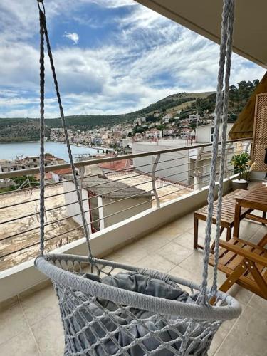 a swing on a balcony with a view of the water at Angel Luxury Aptm Amfilochia in Amfilochía