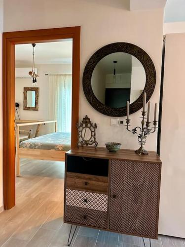 a room with a mirror and a dresser with a room with a bed at Angel Luxury Aptm Amfilochia in Amfilochía