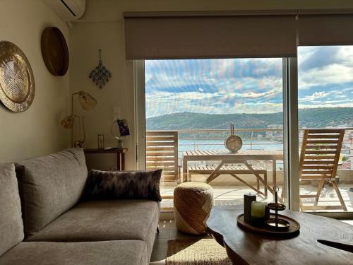 a living room with a couch and a view of the ocean at Angel Luxury Aptm Amfilochia in Amfilochía