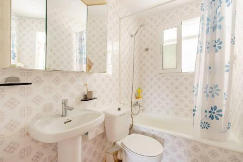 a bathroom with a toilet and a sink and a tub at Сozy House in Alicante