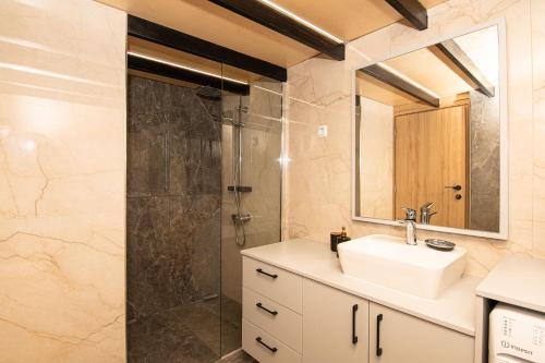 a bathroom with a sink and a shower at Rikanthos Stone Sea View Apartment ΙΙ in Kissamos