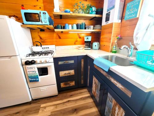 a kitchen with a stove and a sink and a refrigerator at Sea & Sun Cottage #1 in Hampton