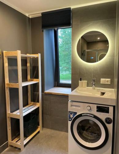 a bathroom with a washing machine and a sink at Apartment by seaside in Ķesterciems