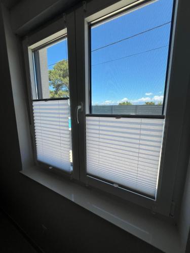 two windows with blinds in a room at Poolhouse Flip Flop - mit privatem Pool in Vir