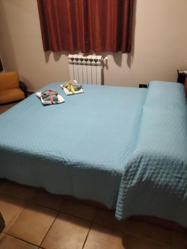 a bed with a blue comforter in a bedroom at Turi house in Messina