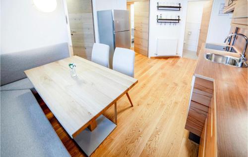 kuchnia z drewnianym stołem i lodówką ze stali nierdzewnej w obiekcie Hochwertige Ferienwohnung w mieście Wagrain