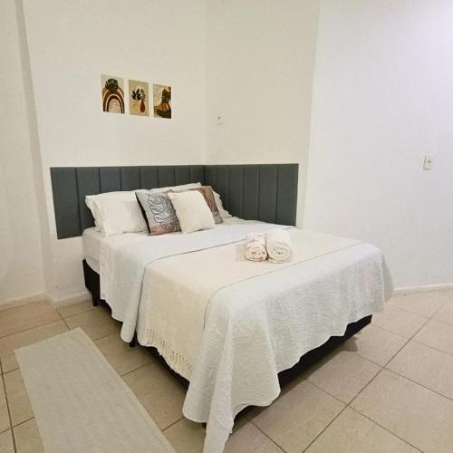 a bedroom with two beds with white sheets and towels at Apêzinho Vidigal - RJ in Rio de Janeiro