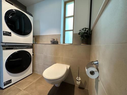 a bathroom with a toilet and a tv on the wall at TRULY - Viel Platz für Business & Familie - Modern, Garage, Fahrstuhl in Augsburg
