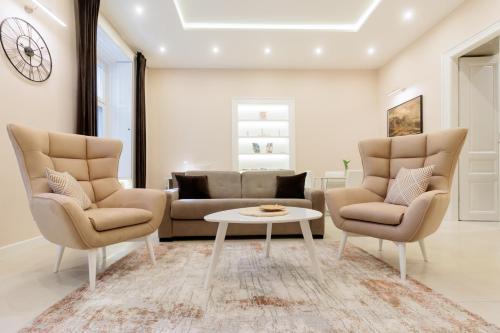uma sala de estar com um sofá e duas cadeiras e uma mesa em Apartman Mirakul em Subotica