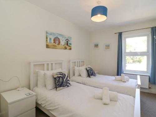 ein Schlafzimmer mit zwei Betten und einem Fenster in der Unterkunft Gone Fishing in Weymouth