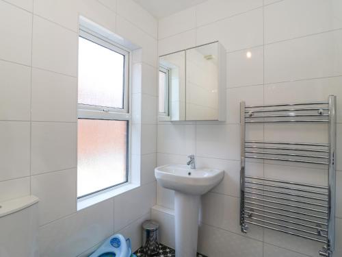 ein weißes Badezimmer mit Waschbecken und Spiegel in der Unterkunft Gone Fishing in Weymouth