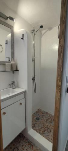 a white bathroom with a shower and a sink at Batsi Bay Loft in Batsi