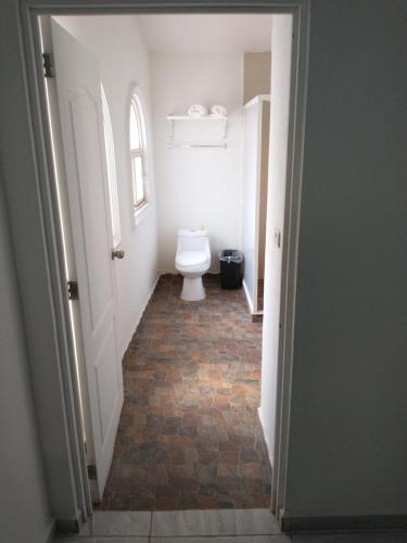 a hallway with a toilet in a white bathroom at Villa Salvatore in Chiconcuac
