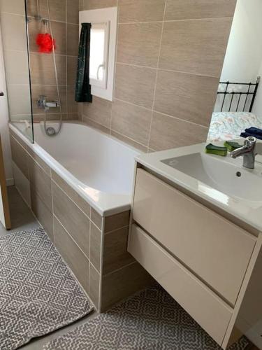 une salle de bain avec une baignoire et un lavabo dans l'établissement Appartement cosy à Sète, à Sète