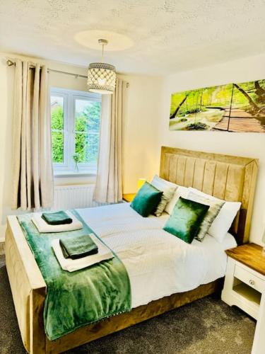 a bedroom with a large bed with green pillows at Luxury 4 bed house in Coventry in Coventry