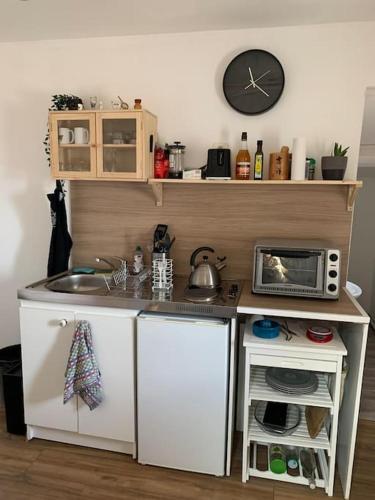 une petite cuisine avec un évier et un micro-ondes dans l'établissement Appartement cosy à Sète, à Sète