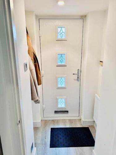 a hallway with a white door with three windows at Luxury 4 bed house in Coventry in Coventry