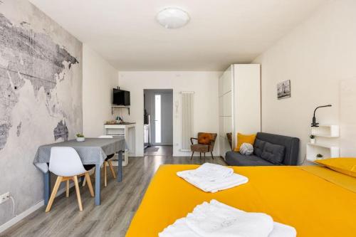 - un salon avec un lit jaune et une table dans l'établissement Cosy apartment near the Lake, à Riva del Garda
