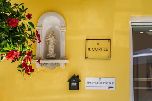 a wall with a statue on a yellow wall at Ciraccio Apartments in Procida