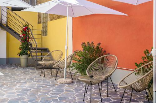 a group of chairs and an umbrella on a patio at Ciraccio Apartments in Procida