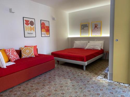 Cette chambre comprend un lit et un canapé. dans l'établissement Cefalhub, à Cefalù