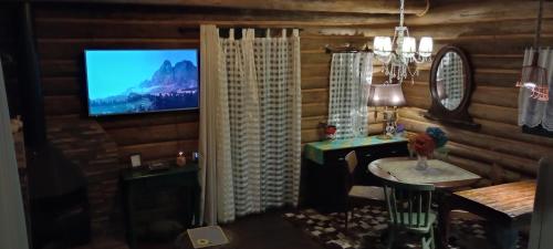 a living room with a television in a log cabin at Casa de toras in Campo Alegre