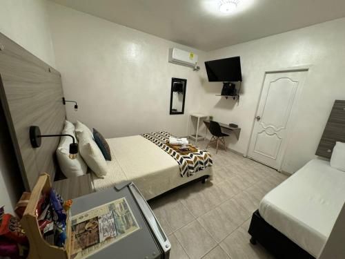 Schlafzimmer mit einem Bett, einem Schreibtisch und einem TV in der Unterkunft Hotel la Sierra Riohacha II in Ríohacha