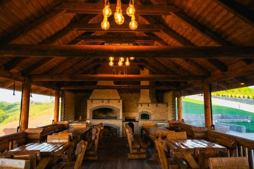a large room with wooden tables and a fireplace at Pyramids Haven in Rîmeţi