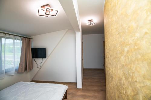 a bedroom with a bed and two lights on the ceiling at Pyramids Haven in Rîmeţi