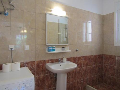 a bathroom with a sink and a mirror at Vivere Apartment Barbati Beach in Barbati