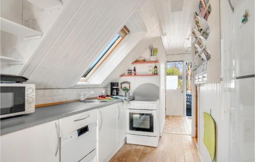 a kitchen with white cabinets and a skylight at Beautiful Home In Sjællands Odde in Yderby
