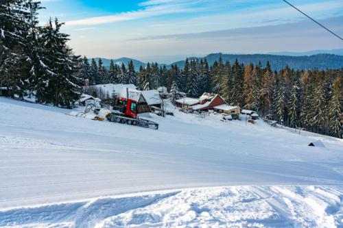 a bulldozer in the snow on a snow covered field at Bačkárka - horská chata in Makov