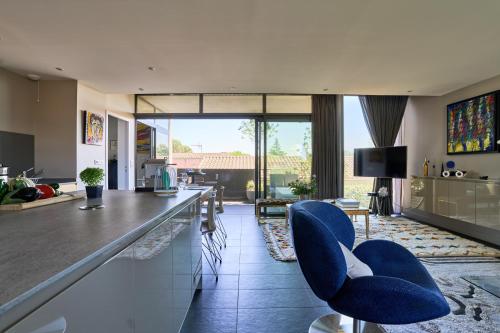 - un salon avec des chaises bleues et un comptoir dans l'établissement Sérénité au fil de l'eau Appartement de standing, à LʼIsle-sur-la-Sorgue