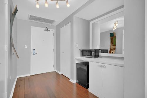 a kitchen with white cabinets and a black microwave at Astonishing SEA VIEW Studio in Grove in Miami