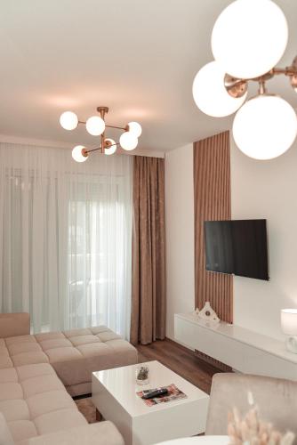 a living room with a couch and a tv at S&L luxury apartman in Banja Koviljača