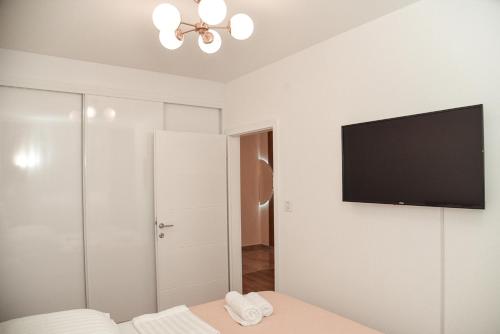 a bedroom with a flat screen tv on the wall at S&L luxury apartman in Banja Koviljača