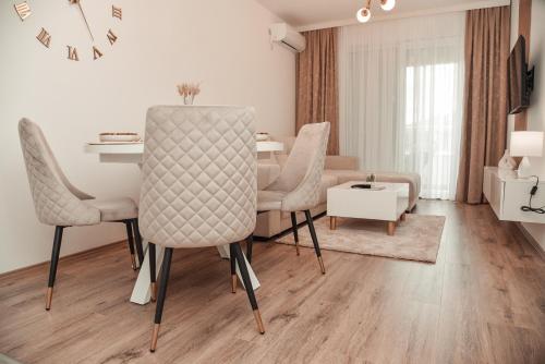 a living room with a dining room table and chairs at S&L luxury apartman in Banja Koviljača